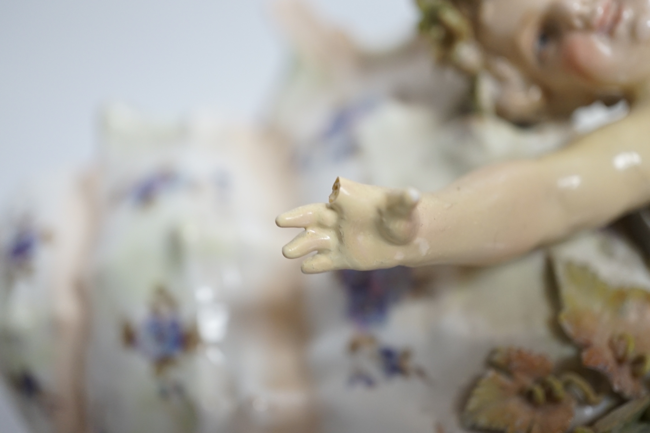 A porcelain shell-shaped centrepiece, a Dresden pill box, a pair of taper holders and a porcelain figure, tallest 21cm